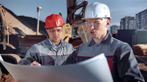 Engineers Reviewing Plans at Construction Site