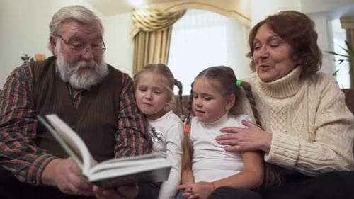 Grandparents Reading a Storybook to Grandchildren at Home