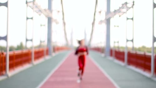 Young Woman Running on City Bridge