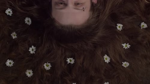 Woman Lies with Flowers in Hair