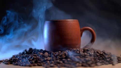 Steaming Brown Mug on Heap of Coffee Beans