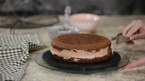 Nicht wiederzuerkennende Konditorin tränkt Biskuitkuchen mit süßem Kaffee