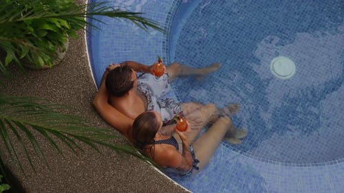 Couple sitting in hot tub together enjoying a drink. Shot on RED EPIC for high quality 4K, UHD, Ultr