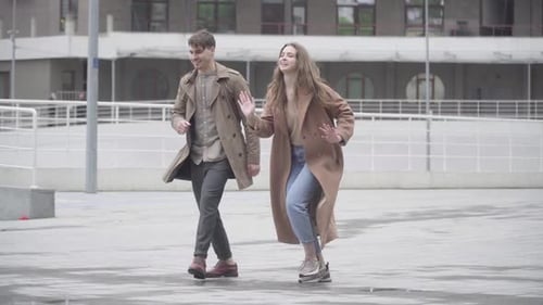 Wide Shot of Cheerful Young Couple Dancing Outdoors on Urban City Street
