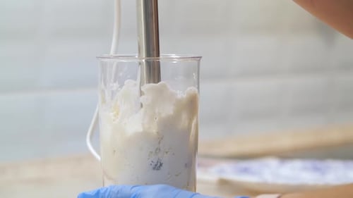 Immersion Blender Mixing White Food in Container