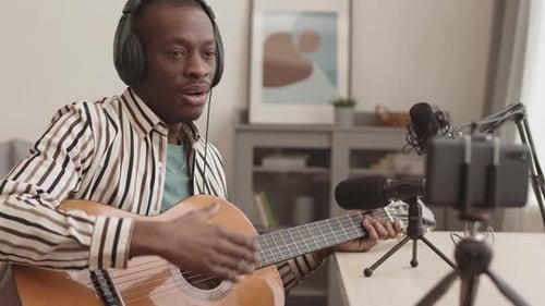 Man Recording Guitar Music Tutorial at Home