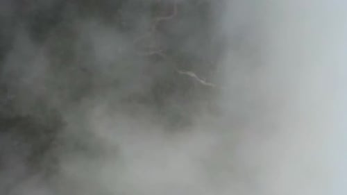 Scenic Aerial View of Green Landscape Through Clouds