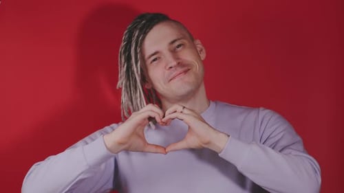 Man with Dreadlocks Makes Heart Shape with Hands