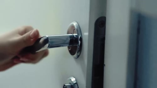 Hand Opens White Interior Door with Metal Handle