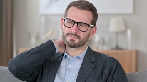 Man Rubbing Neck Due to Discomfort