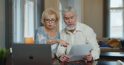 Senior Couple at Home Use Laptop Together