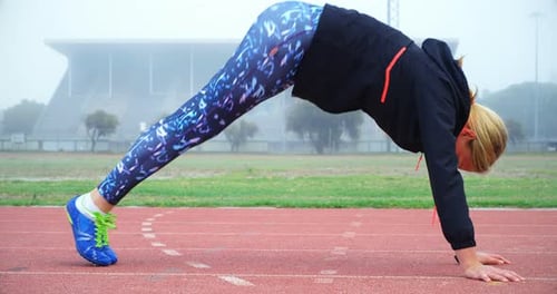 Female Athlete Stretching on Outdoor Running Track