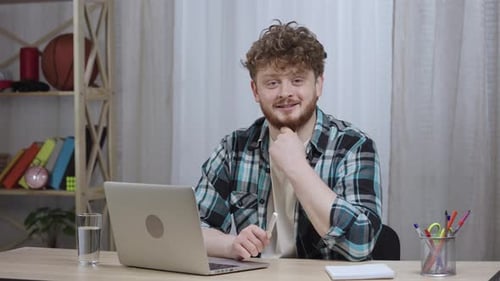 Smiling Man at Desk with Laptop Indoors