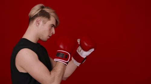 Young Adult with Blonde Hair Posing with Boxing Gloves