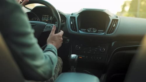 Mann fährt Auto die Straße entlang Die untergehende Sonne scheint in der Windschutzscheibe