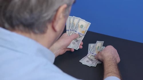 Man Counting Stack of Hundred Dollar Bills