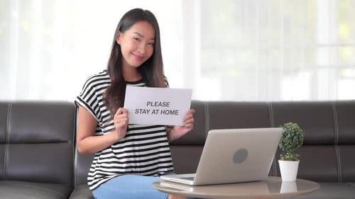 Woman Smiling, Holding "Stay At Home" Sign