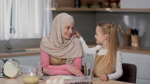 Smiling Woman and Child Baking Together in Kitchen
