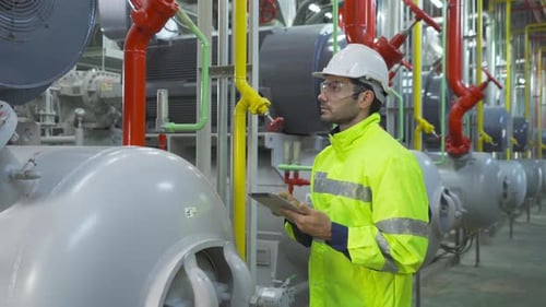An engineer man or worker, people using a tablet device, working in industry factory. Chiller tower