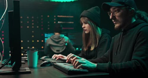 Team Hacking Computers in Dark Urban Workspace