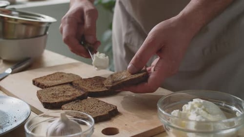 Man Spreads Cream Cheese on Toast for Snack