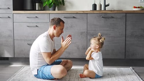 Father and Daughter Playing Clapping Games Indoors