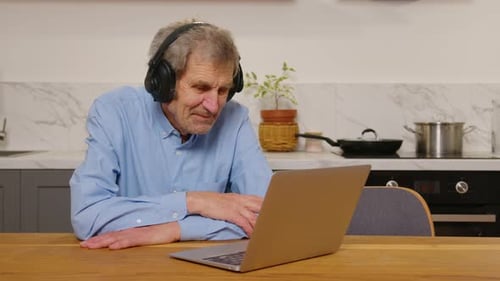 Senior Man Using Laptop for Video Call at Home