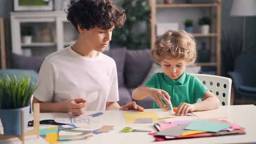 Creative Family Mom and Small Child Doing Collages with Paper, Scissors and Glue