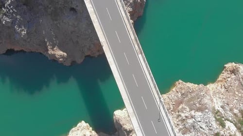 Puente de coches vacío sobre el río con aguas cristalinas de color turquesa y acantilados de
