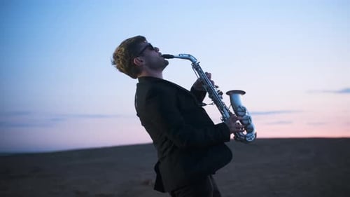 Saxophone Player Performing in Desert at Sunset