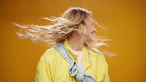 Young Woman Shaking Her Head Against Yellow Background in Studio