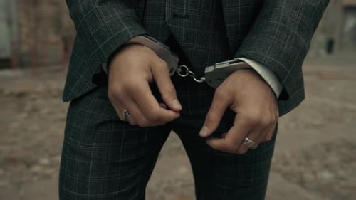 Man Wearing Suit in Handcuffs outdoors