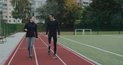 Athletic Woman and Man with Prosthetic Leg Walking
