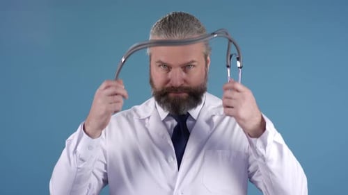 Man Wearing White Coat Puts On Stethoscope