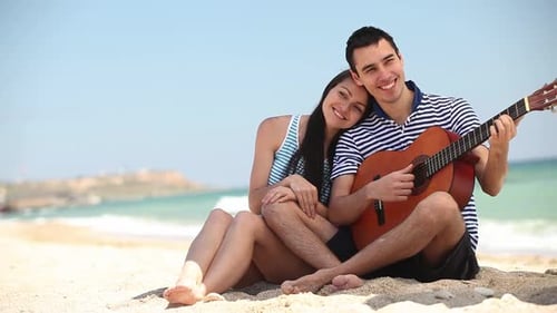 happy young couple embracing on the sand on the beach,
