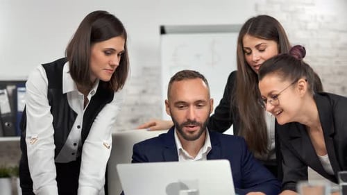 Business Colleagues Working Together Around Laptop in Office