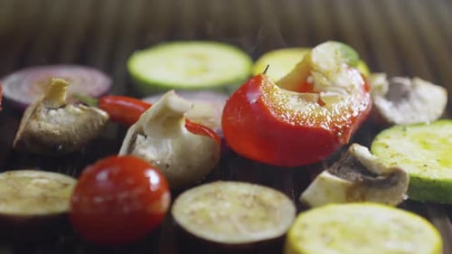 Trozos de tomate, champiñones, cebolla, berenjena, calabacín y chile ahumados en la parrilla