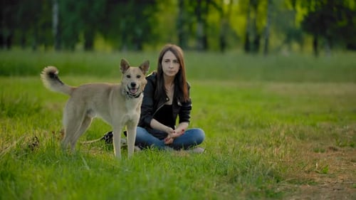 Woman Plays Fetch with Dog in Green Park