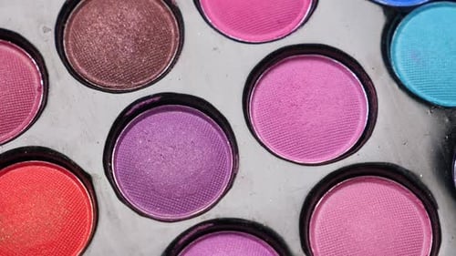 Applying Colorful Eye Shadow with Brush on Palette