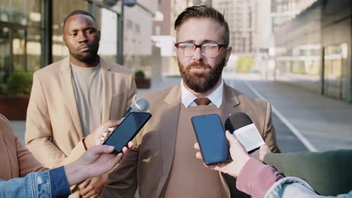 Man Giving Interview to TV Journalists Outdoors on Street