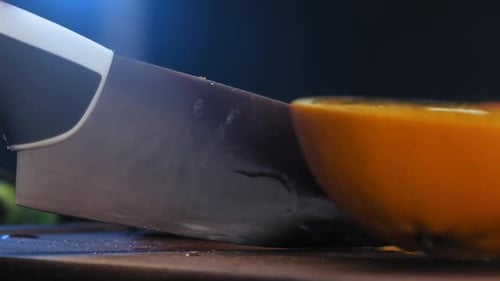 Fresh Orange Being Sliced on Cutting Board