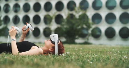 Woman Enjoys Virtual Reality in a Grassy Urban Setting