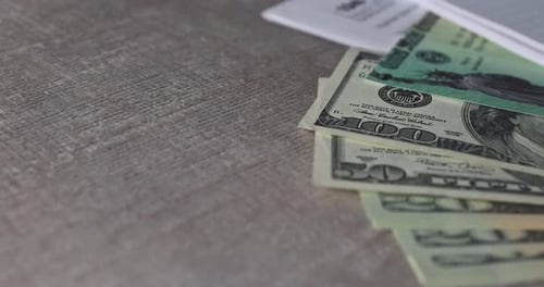 IRS 1040 Tax Return Form with Currency US Dollar Banknotes Close Up