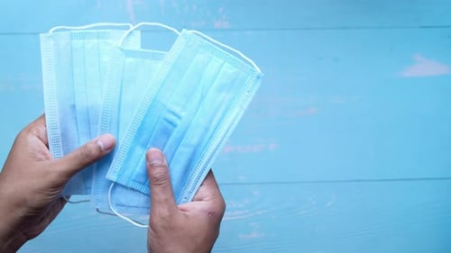 Man Hand Holding Surgical Face Mask, Top View