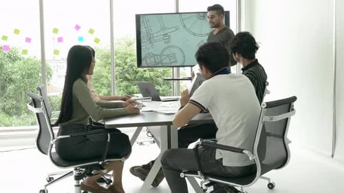 Team Discussing Blueprints at Business Office Meeting