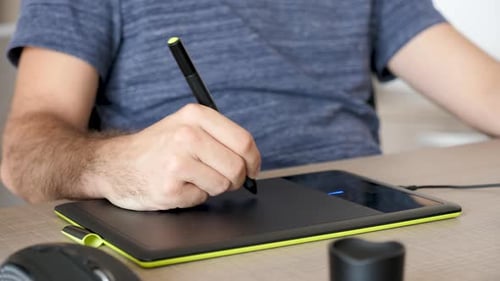Designer Using Stylus and Graphics Tablet at Desk
