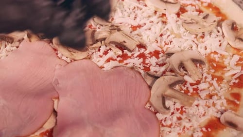 Close up of Ham and Mushroom Pizza Being Made