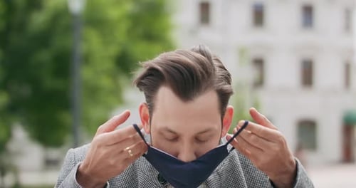 Man Puts on Protective Face Mask in City