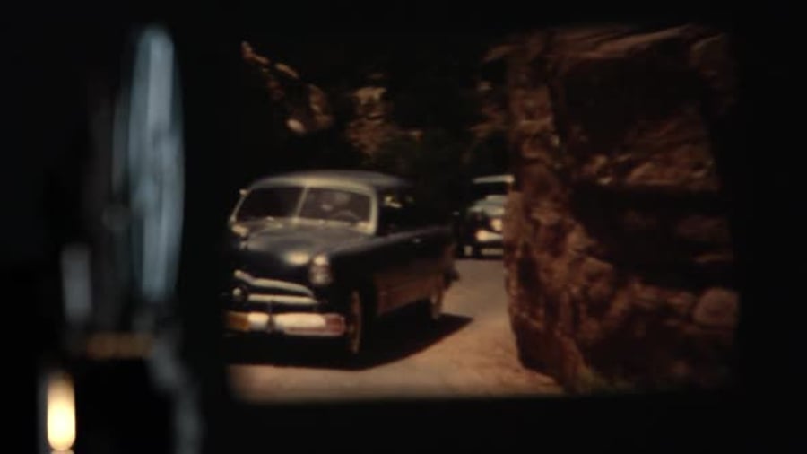 Cover for View of projector playing old film of cars driving