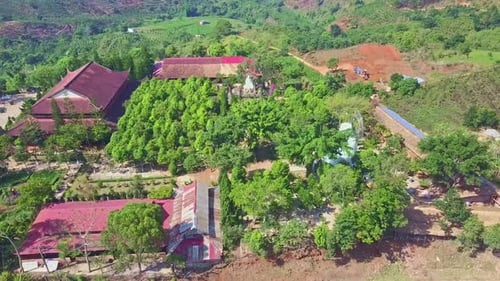 Drone Rotates Over Pagoda Territory Against Green Hills